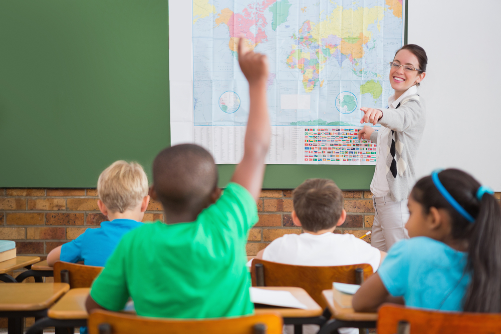 Pupil raising hand in classroom at the elementary school